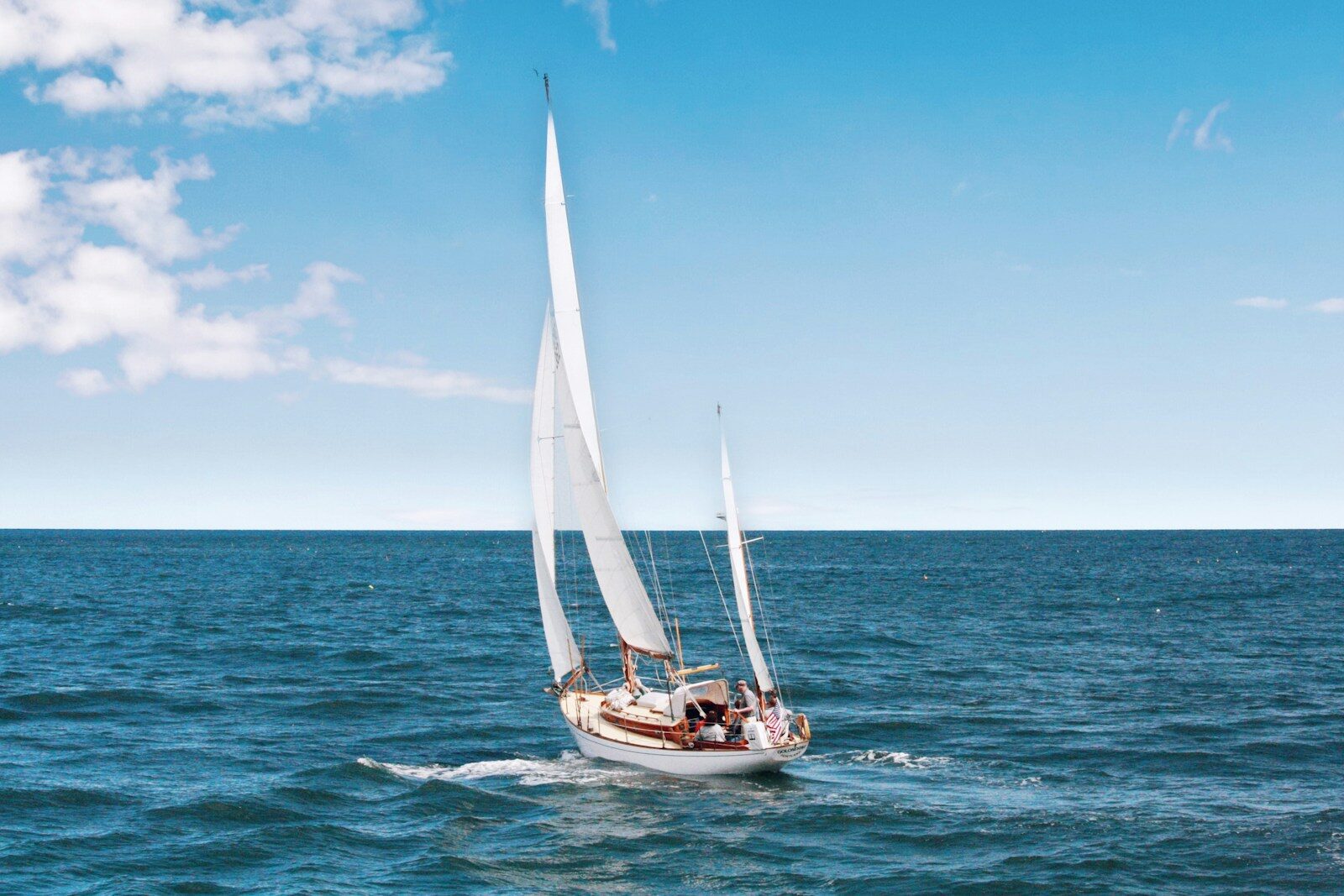 Photo by Kristel Hayes white sail boat on body of wate